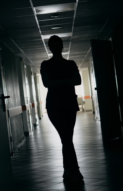 Silhouette of a person standing in a dark hallway.