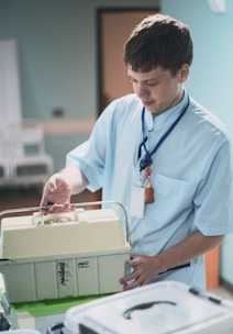 Young man in medical uniform holding a medical case