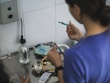 A person preparing a syringe with blue liquid.