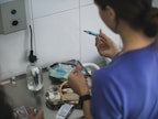 A person preparing a syringe with blue liquid.