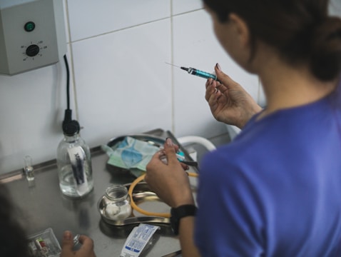 A person preparing a syringe with blue liquid.