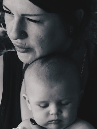 Mother holds her baby close in black and white.