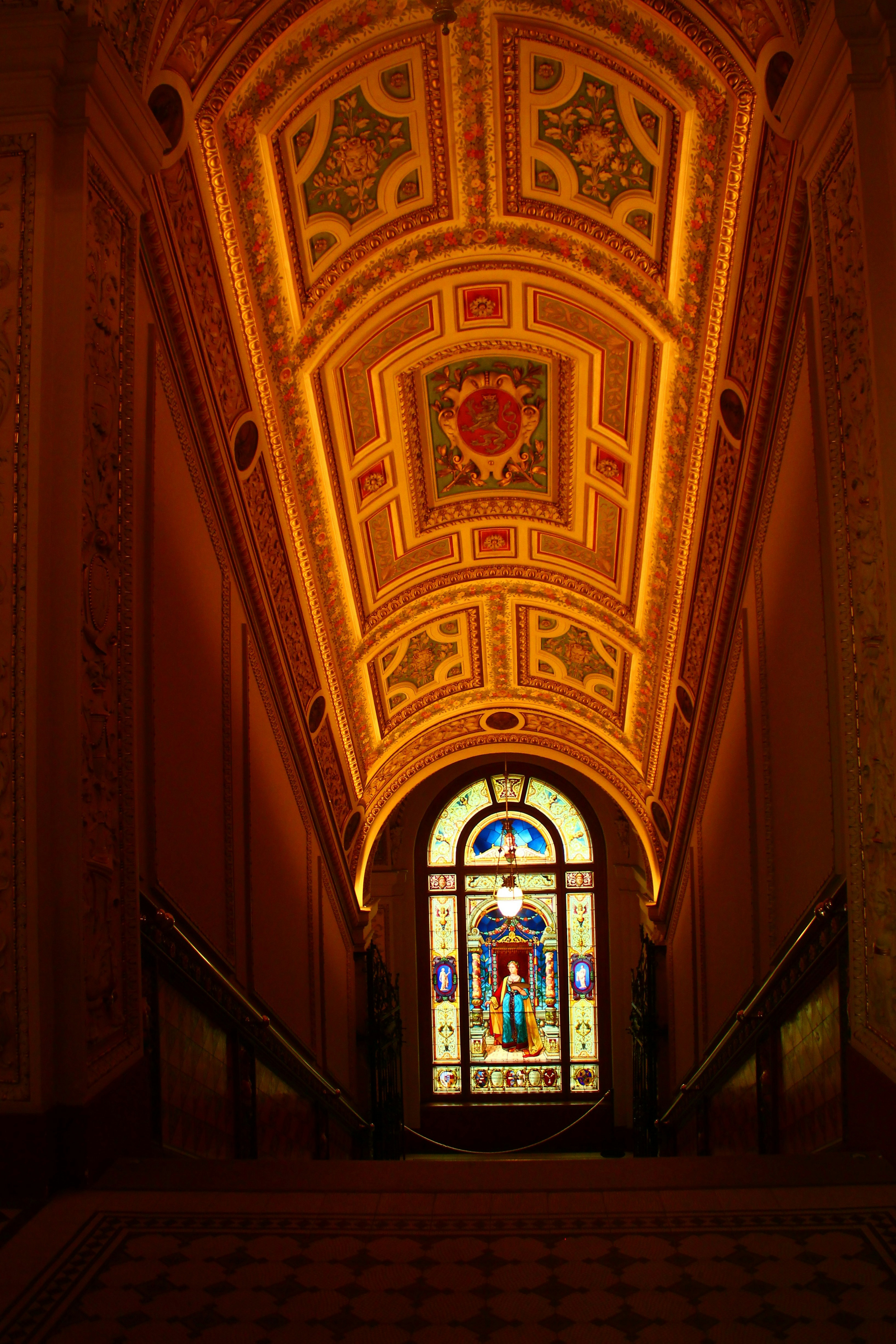 ステンドグラスの窓と金色の天井のある華やかな廊下