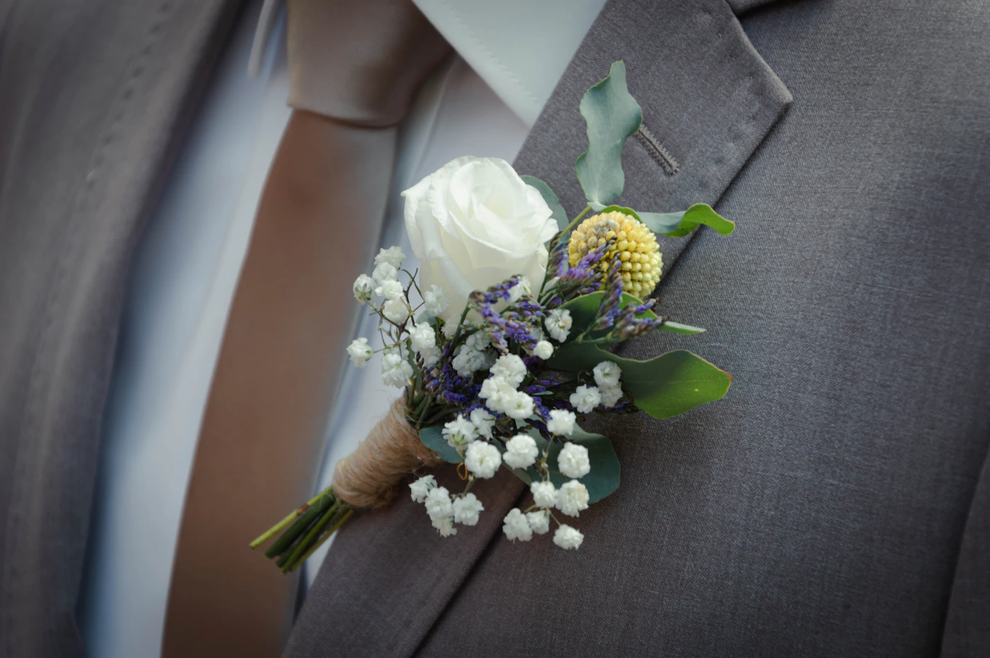 How to make your own boutonnieres — An array of floral tape, wire, scissors, and fresh flowers laid out for boutonniere making.