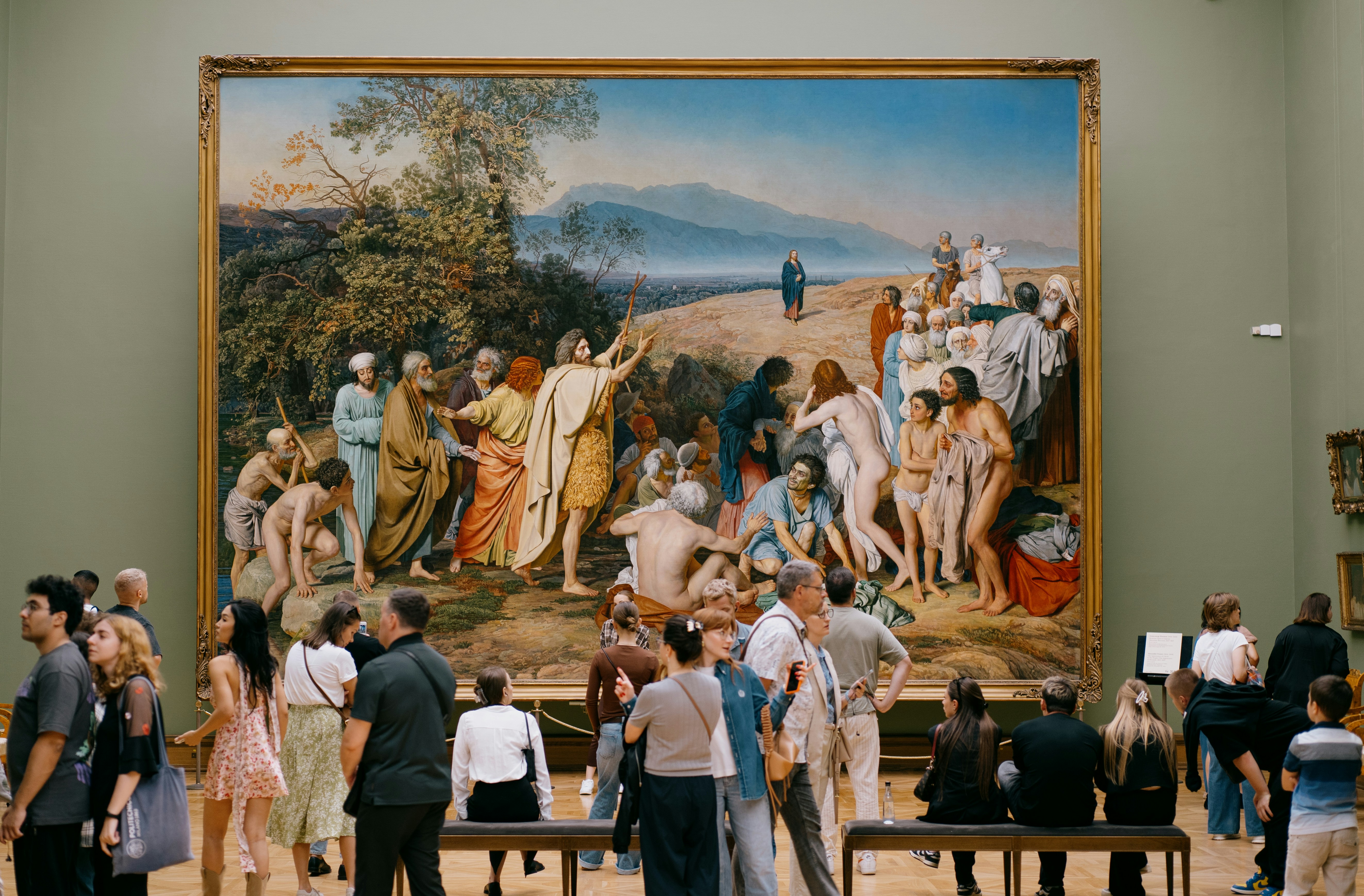 A diverse group of people admiring the Diego Rivera Court murals, showcasing the museum's grandeur. - detroit art museum cost