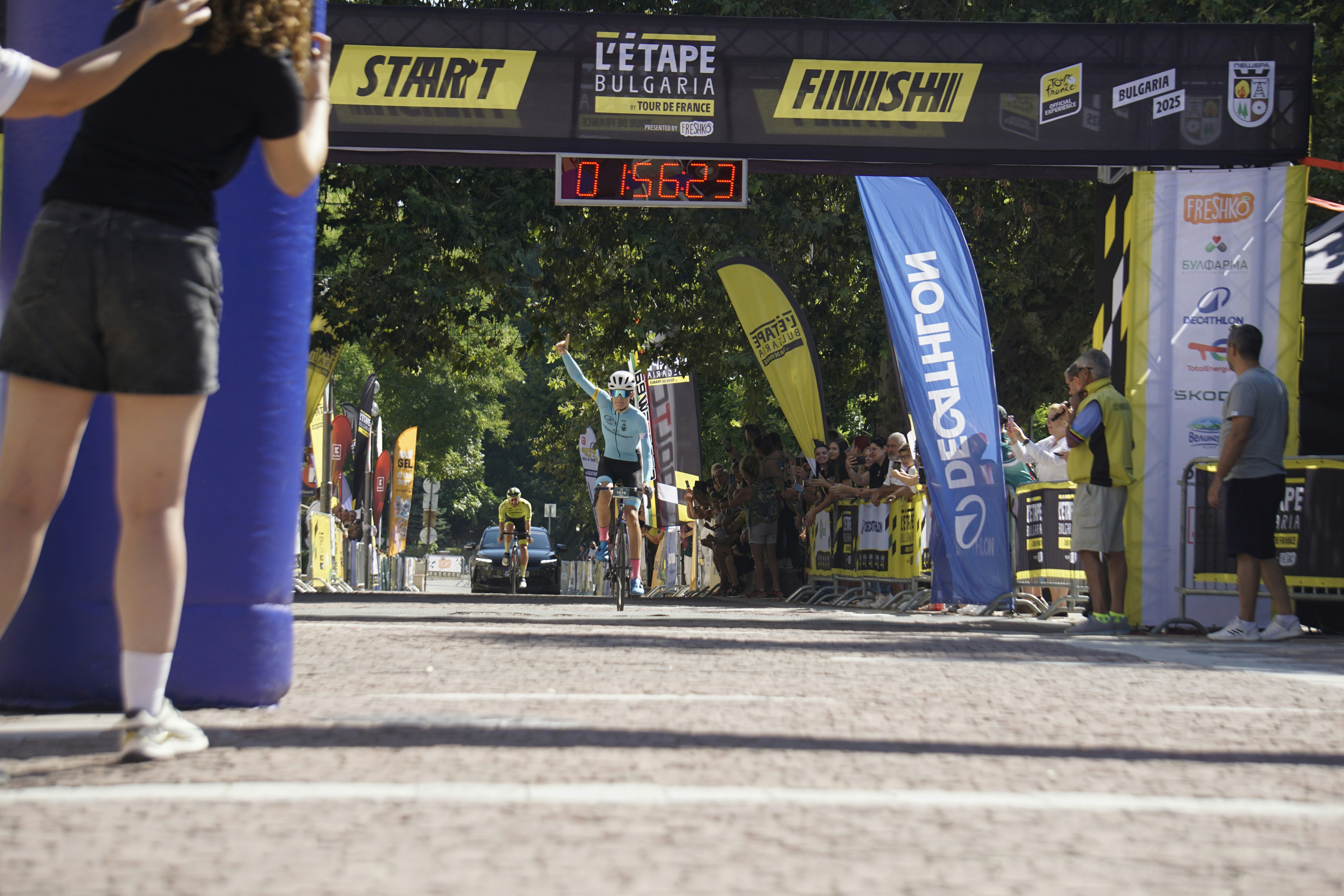 Radfahrer überquert die Ziellinie mit erhobenen Armen