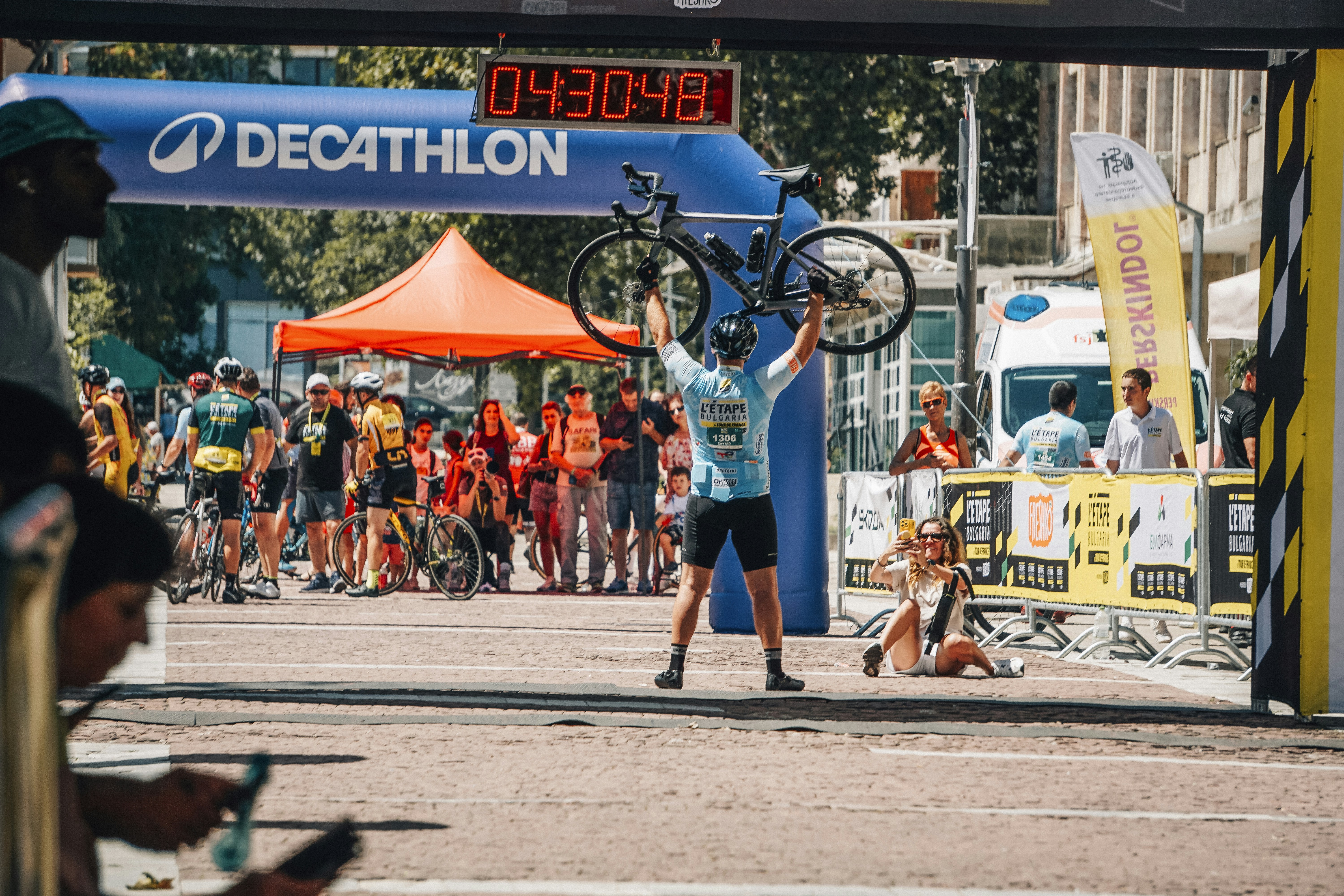 Cyclist celebrates victory holding bike above head