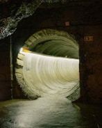 Illuminated circular tunnel with rough stone entrance