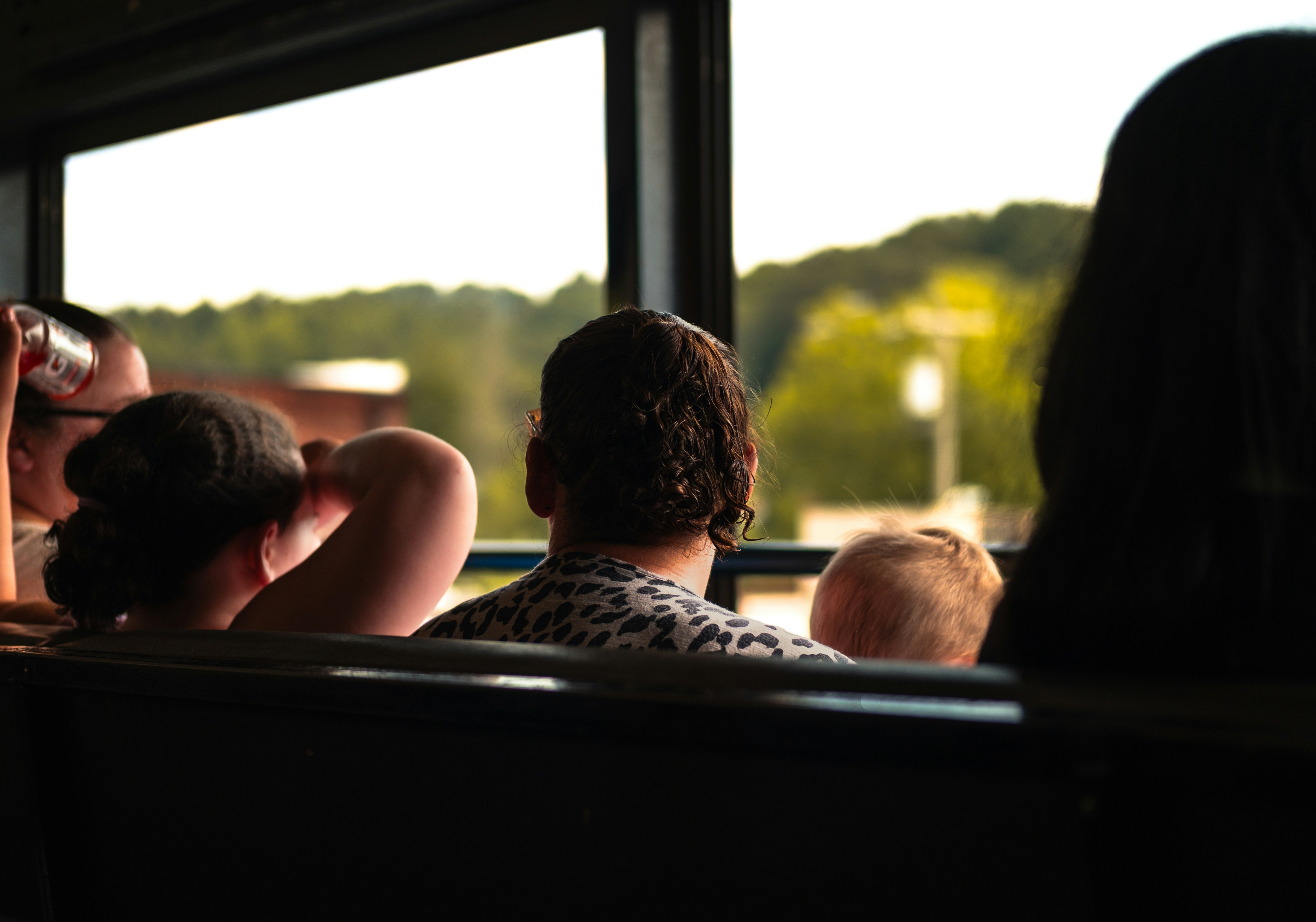 People looking out of a bus window at scenery