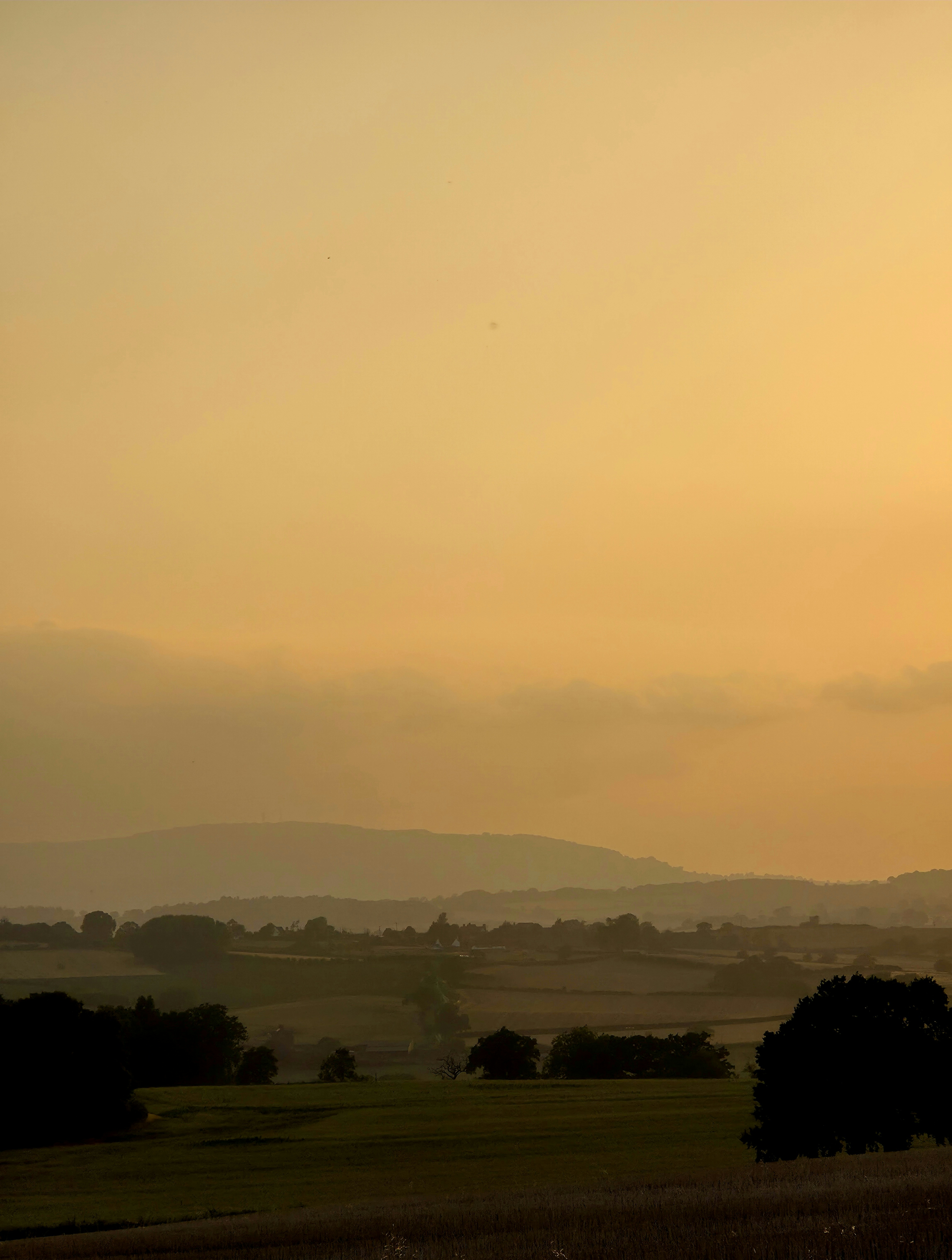 Golden sky over rolling hills at sunset