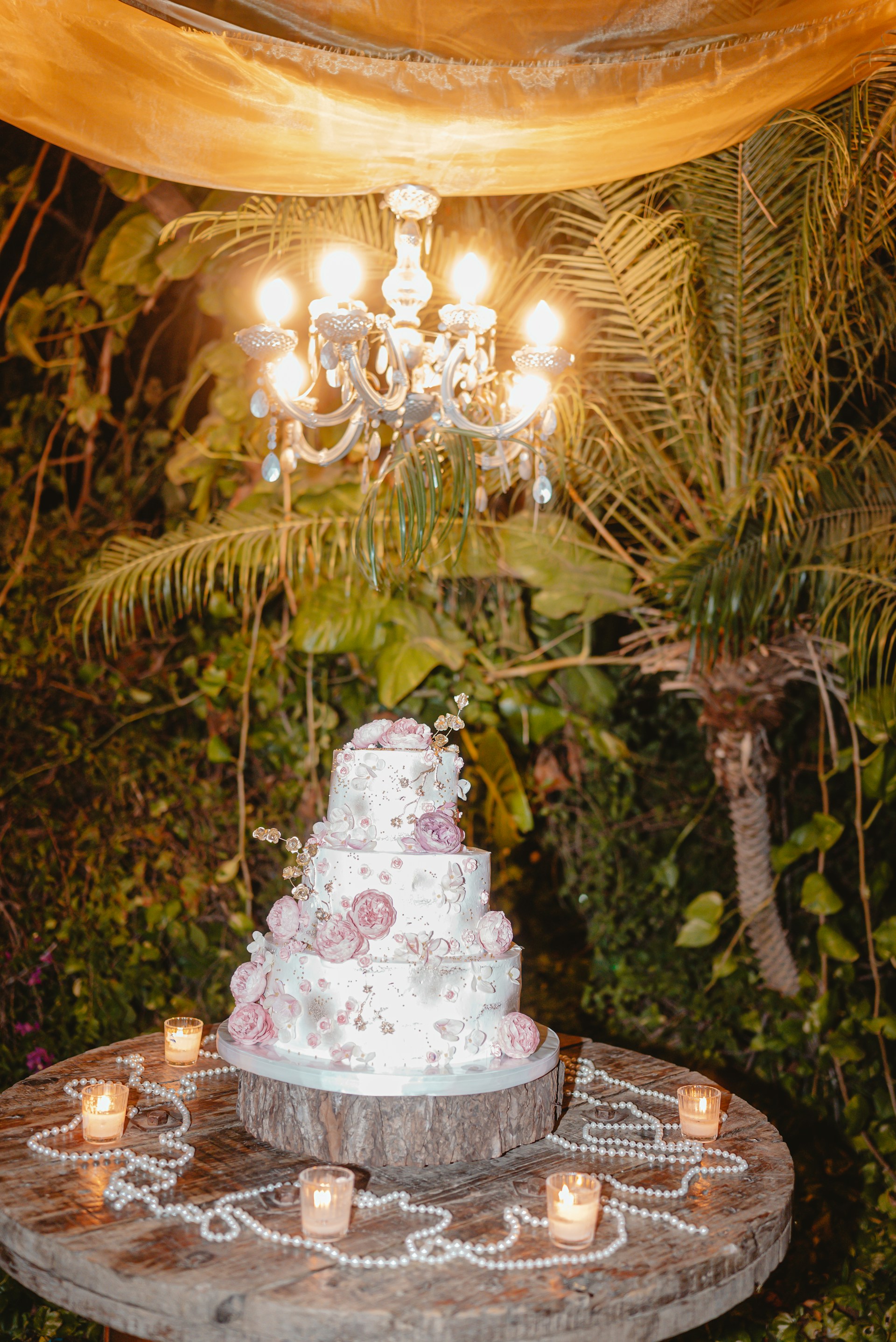 Elegant tiered cake with floral decorations and candles