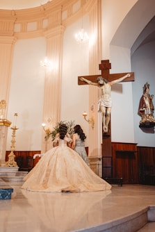 Young woman in a formal gown before a crucifix