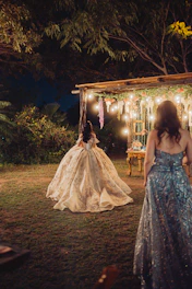 Woman in ornate gown at nighttime outdoor event