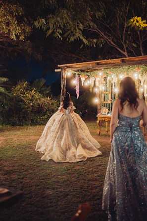 Woman in ornate gown at nighttime outdoor event