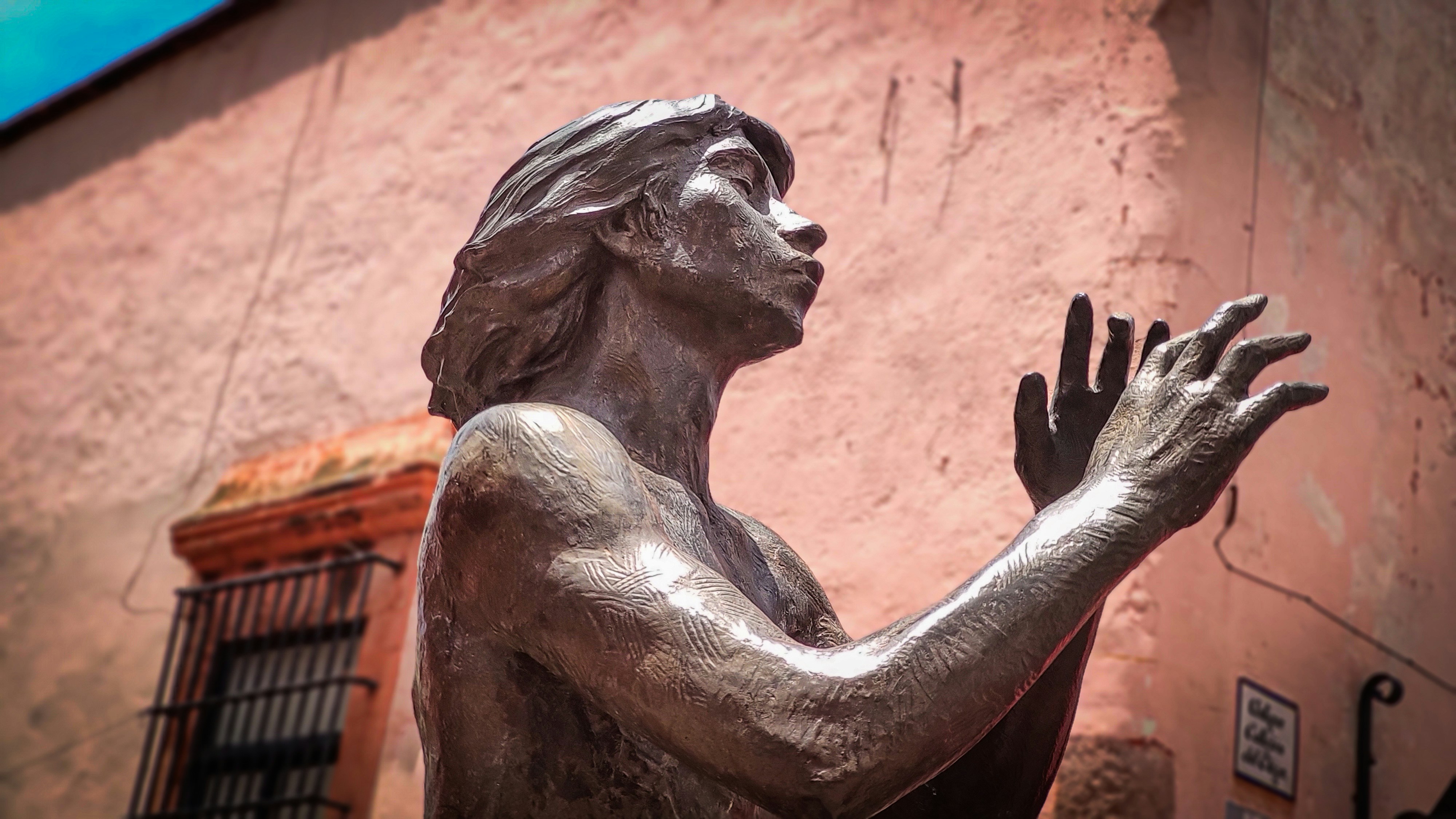 Bronze statue of a person clapping hands