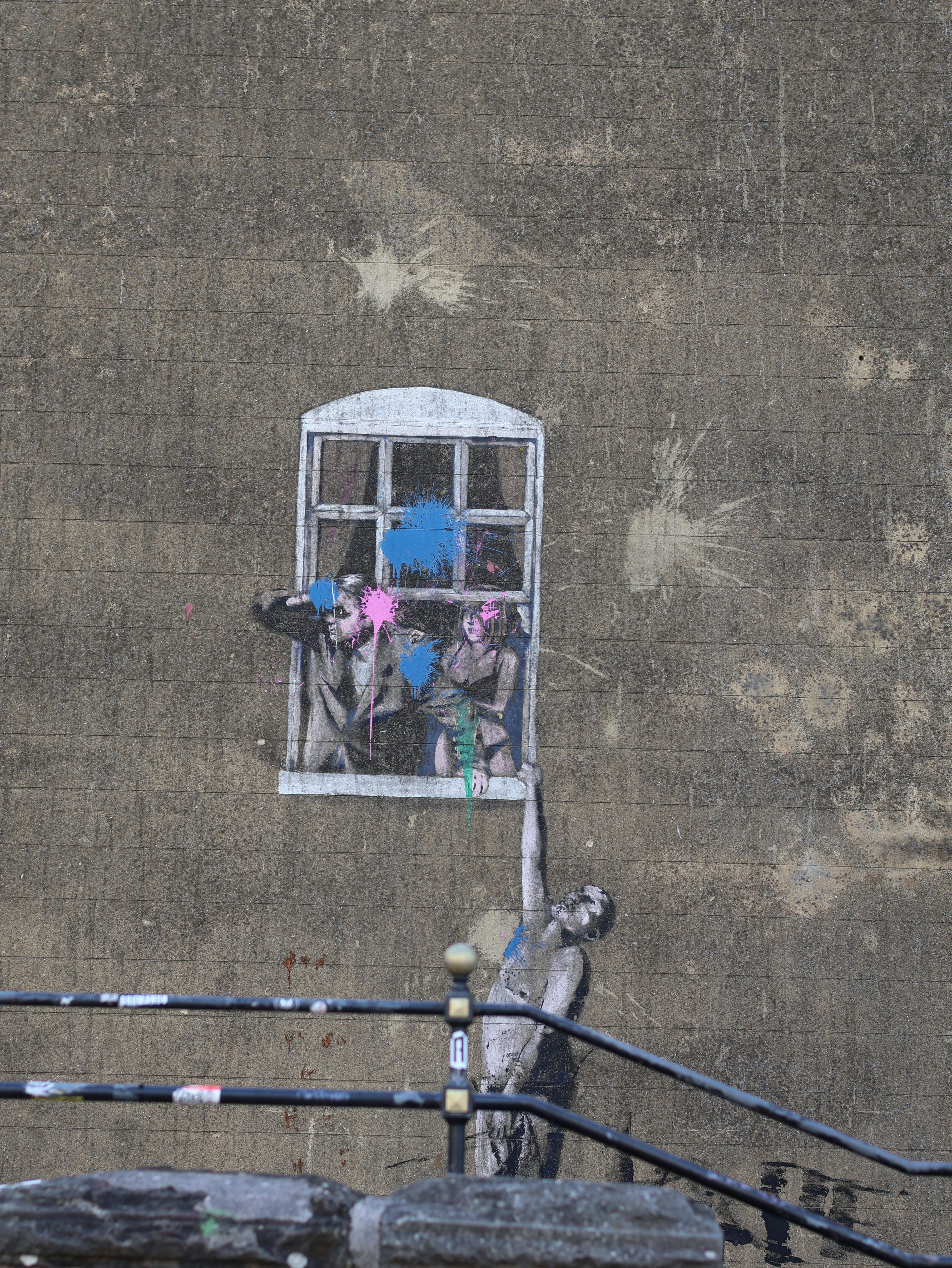 Graffiti art depicts people reaching from a window