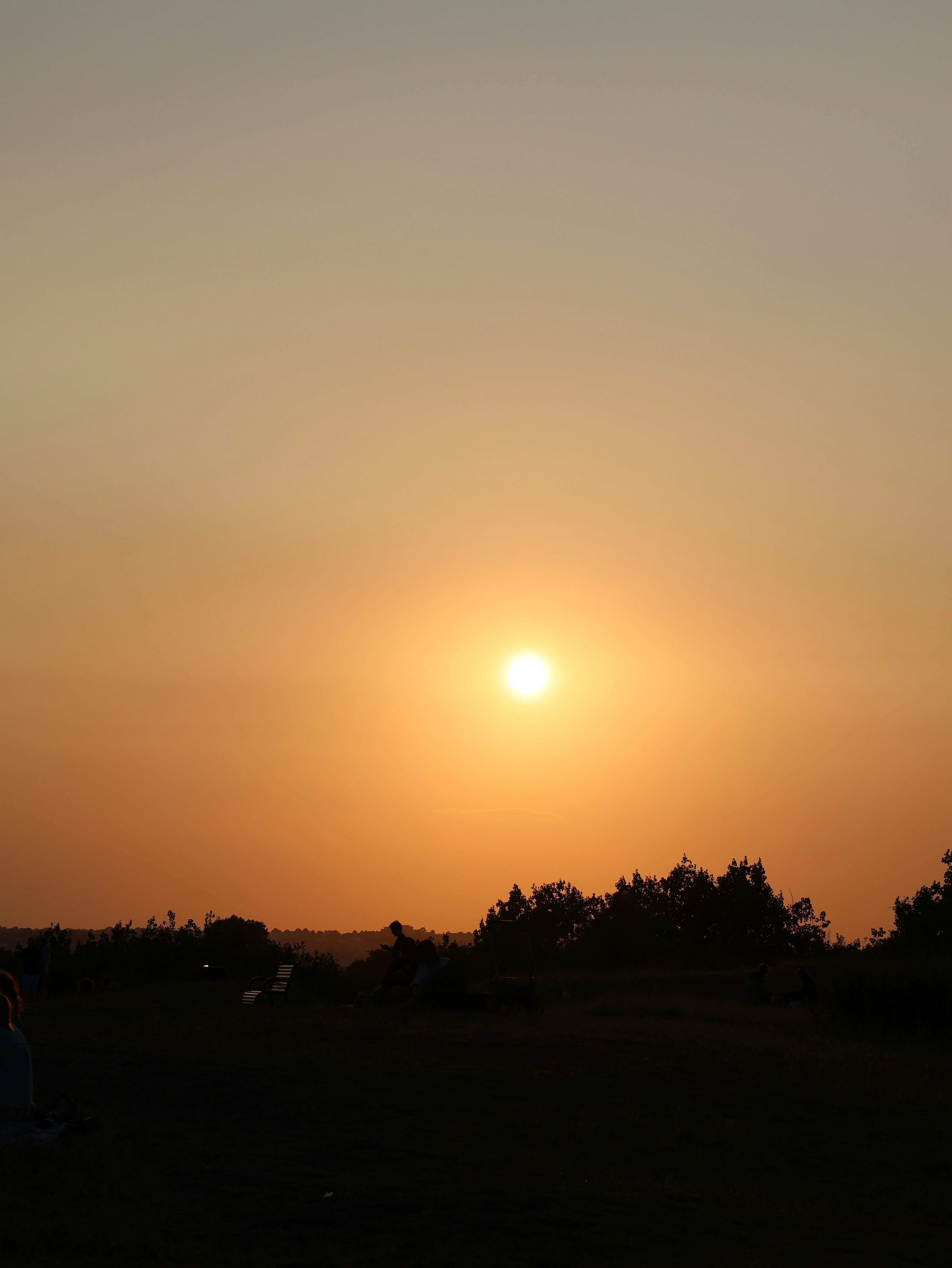 Sun setting over a silhouetted landscape