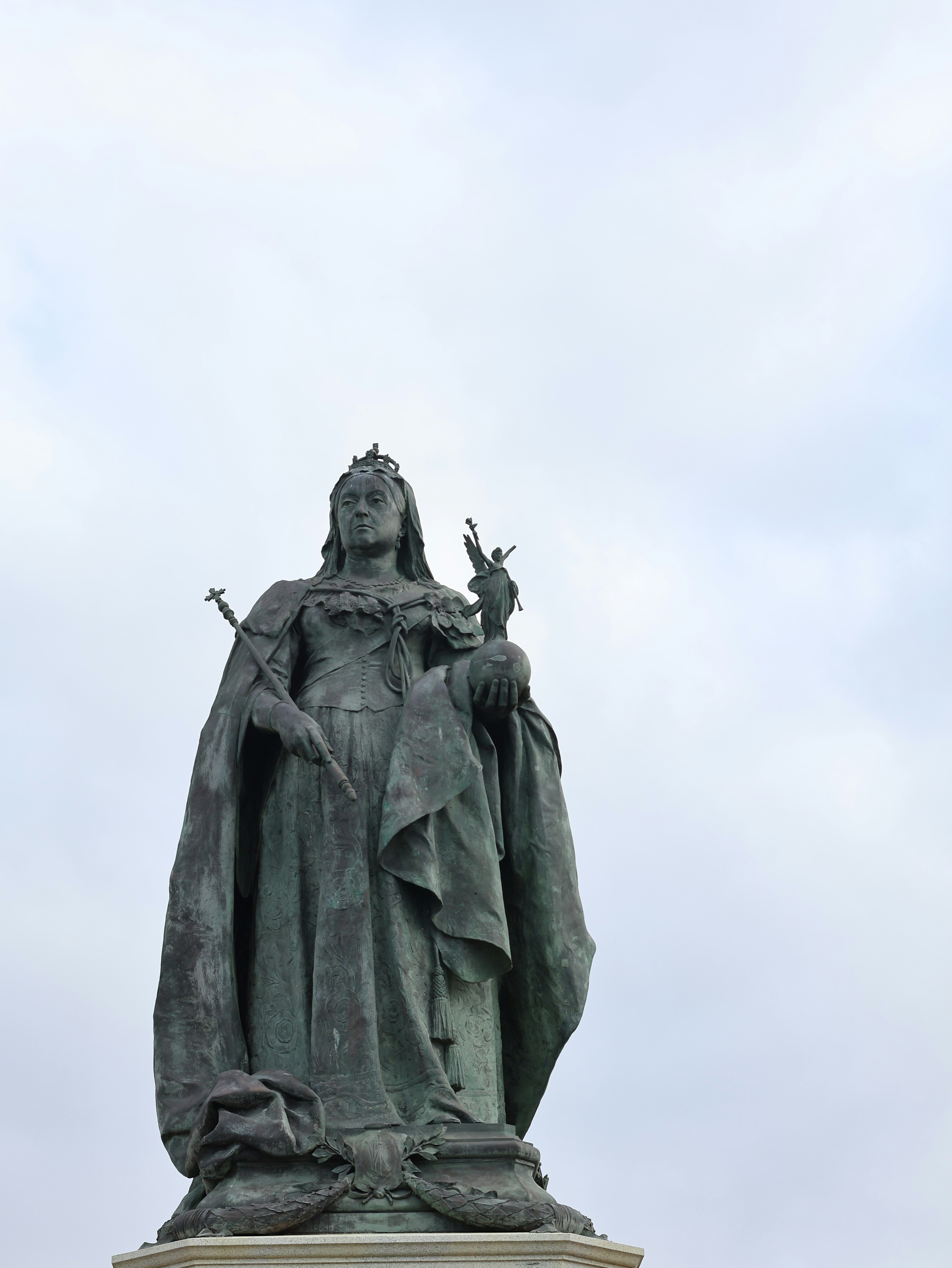 Queen victoria statue against a cloudy sky