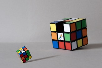 Two rubik's cubes on a gray surface