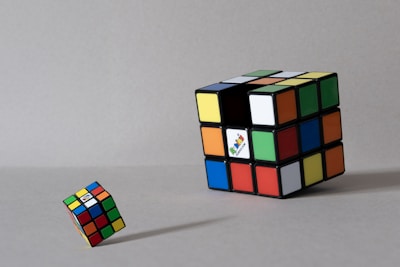Two rubik's cubes on a gray surface