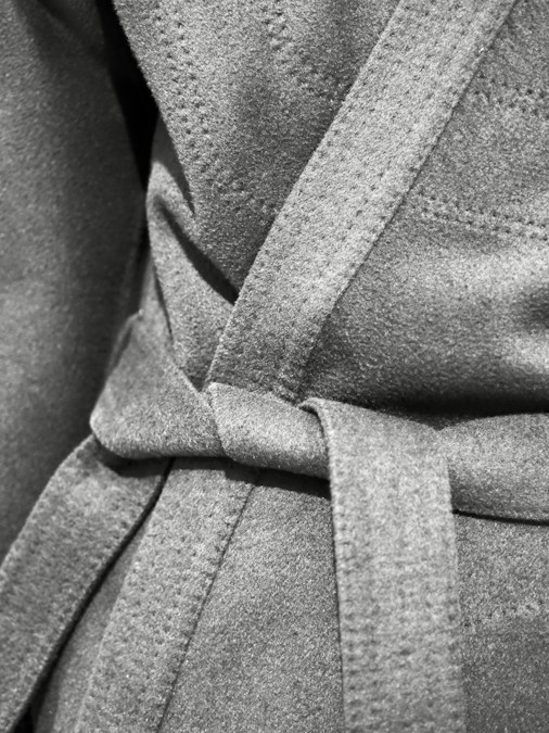 Gros plan sur la ceinture nouée d’un manteau en laine grise, en illustration des tendances de l’hiver 2026-2027