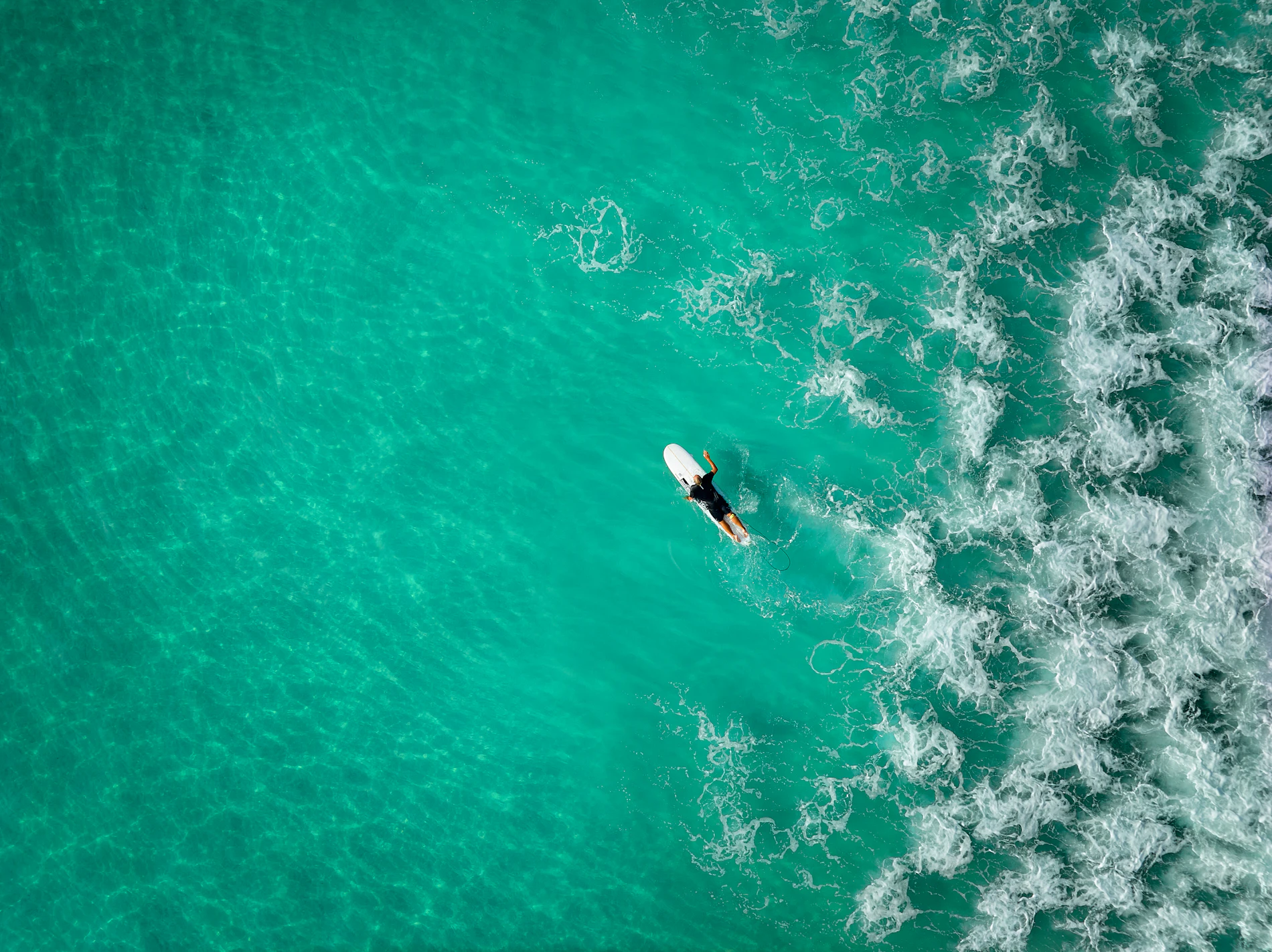 Compétiteur en paddle board fendant une vague turquoise en sauvetage côtier