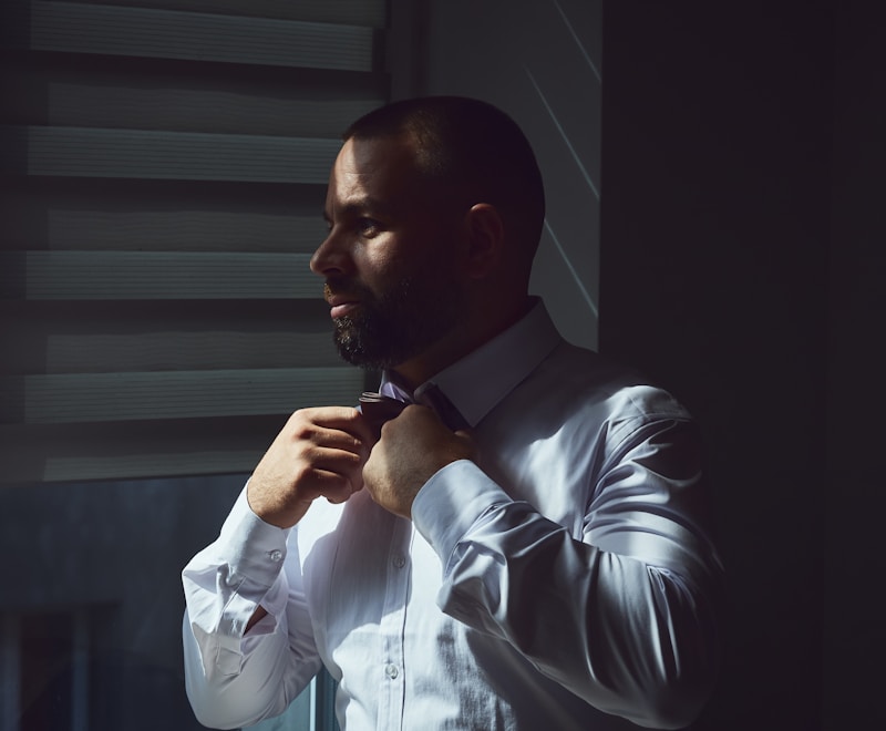 Man in white shirt adjusting his bow tie
