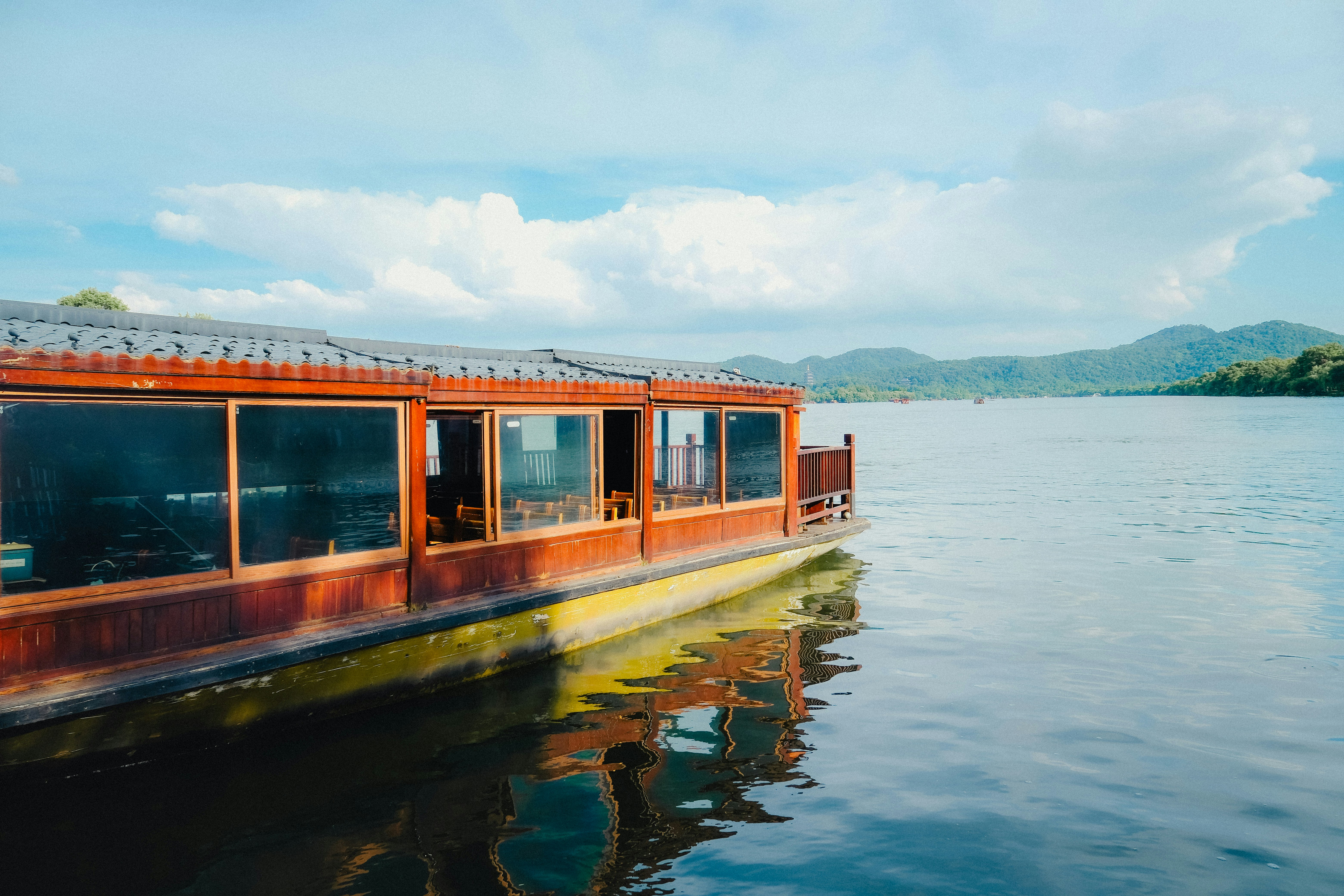 Wooden boat on calm blue water under cloudy sky
