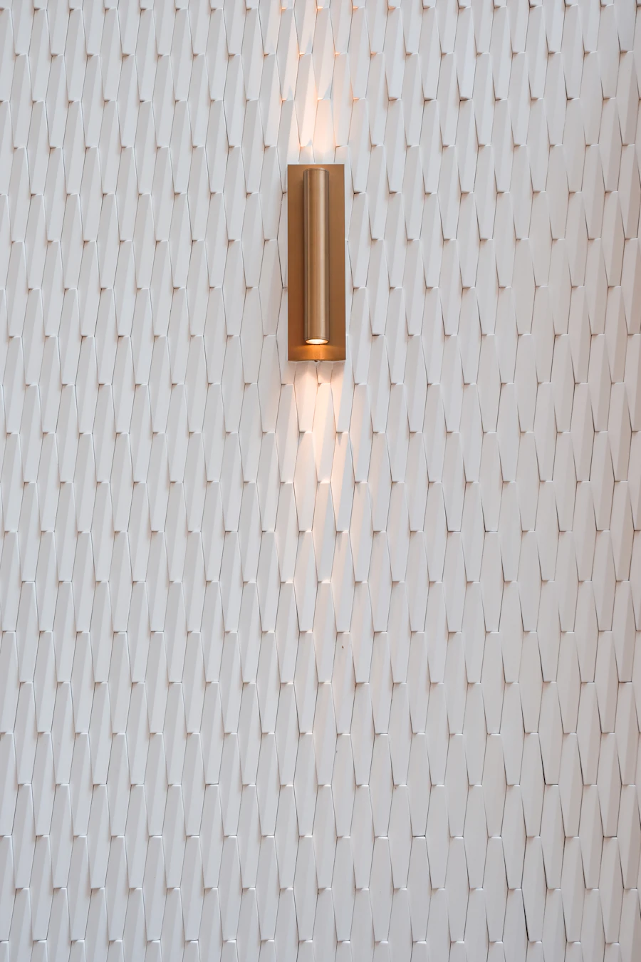 Smart dimmable wall sconce illuminating a textured wall