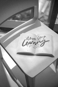 Open book with "never stop learning" quote on chair