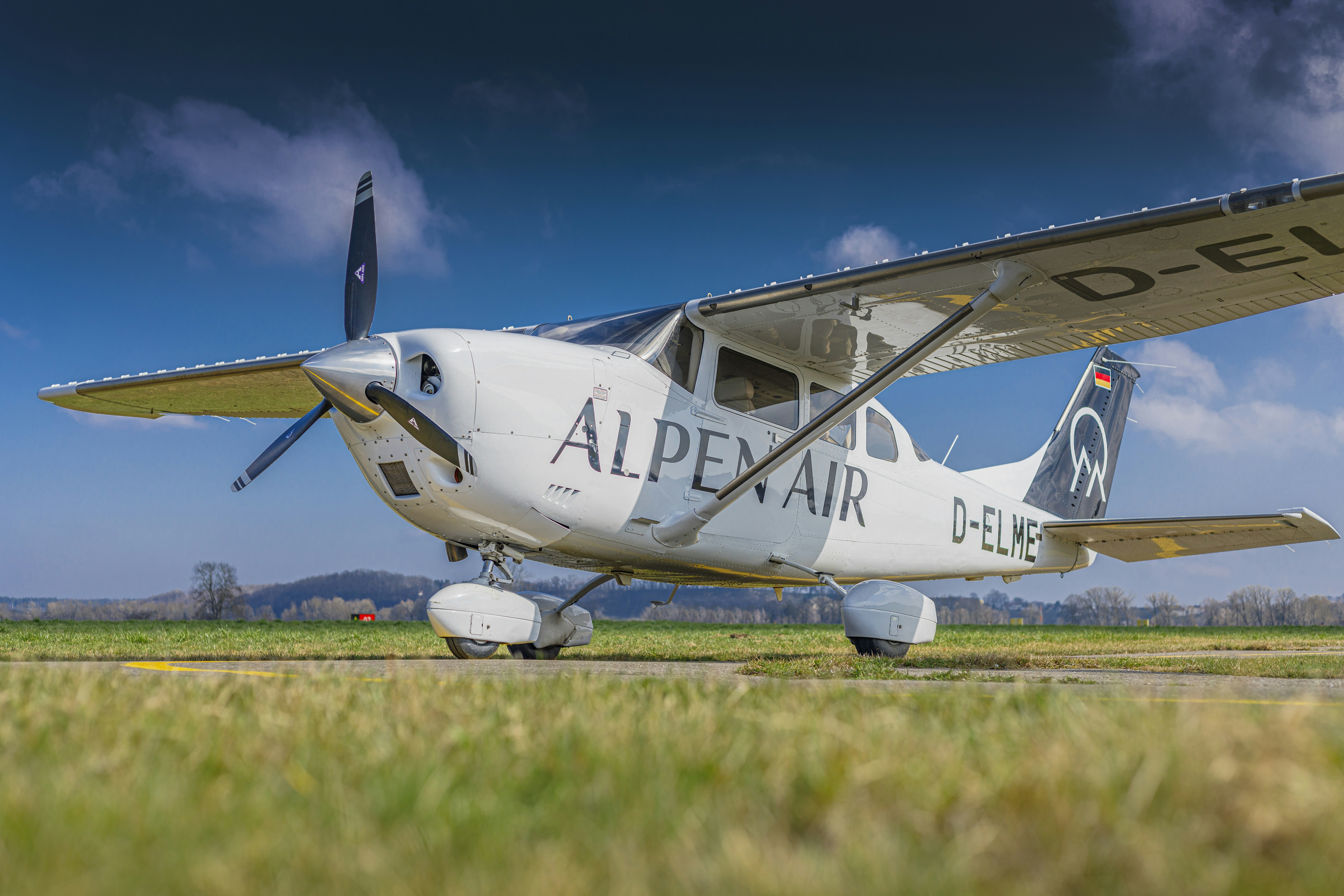 White single-engine airplane parked on tarmac