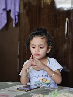 Young girl looking at a smartphone on a table
