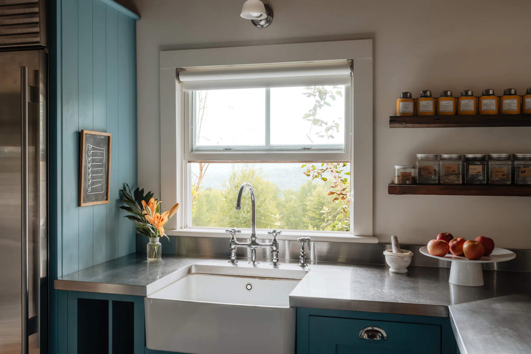 Farmhouse kitchen with blue cabinetry, apron-front sink, stainless worktop and open shelves