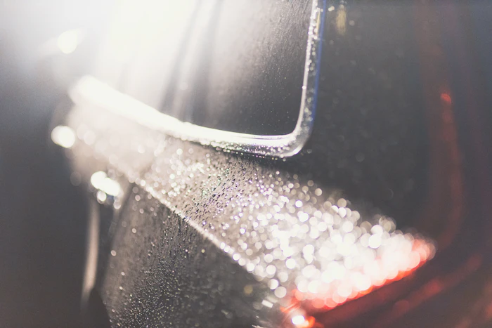 Close up water droplets on dark car surface