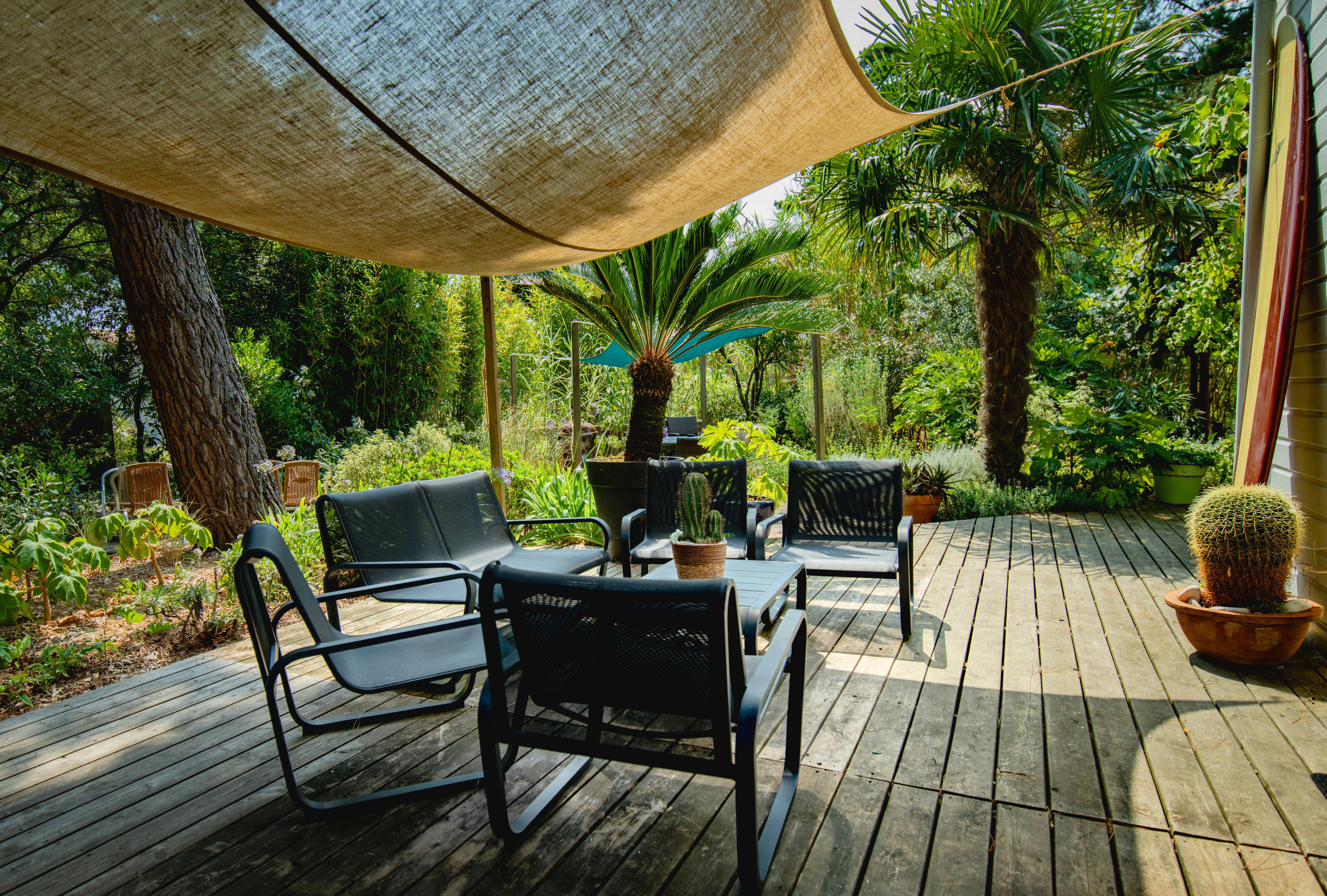 Outdoor seating area with chairs and table under canopy.