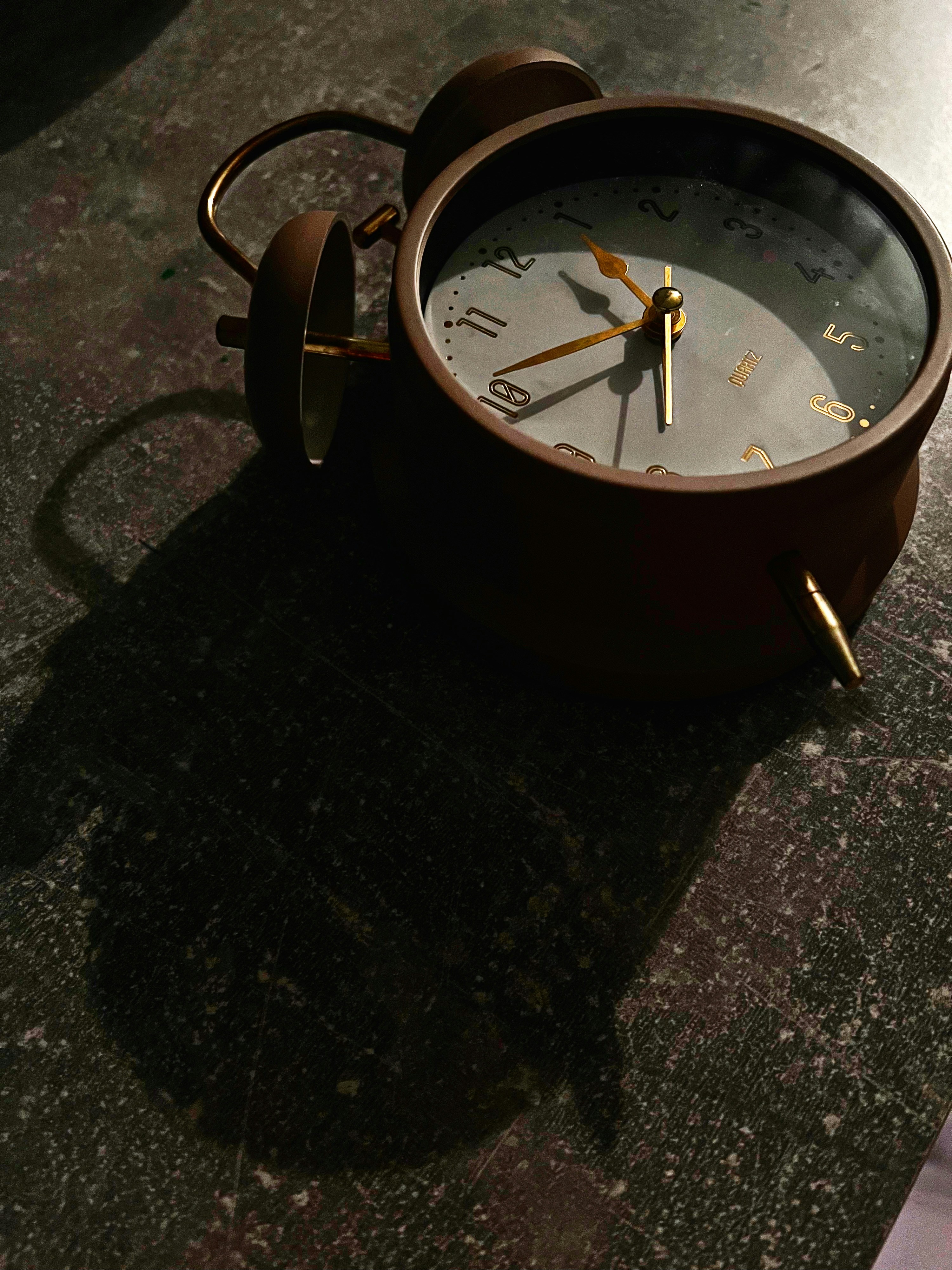 Vintage alarm clock casting a long shadow