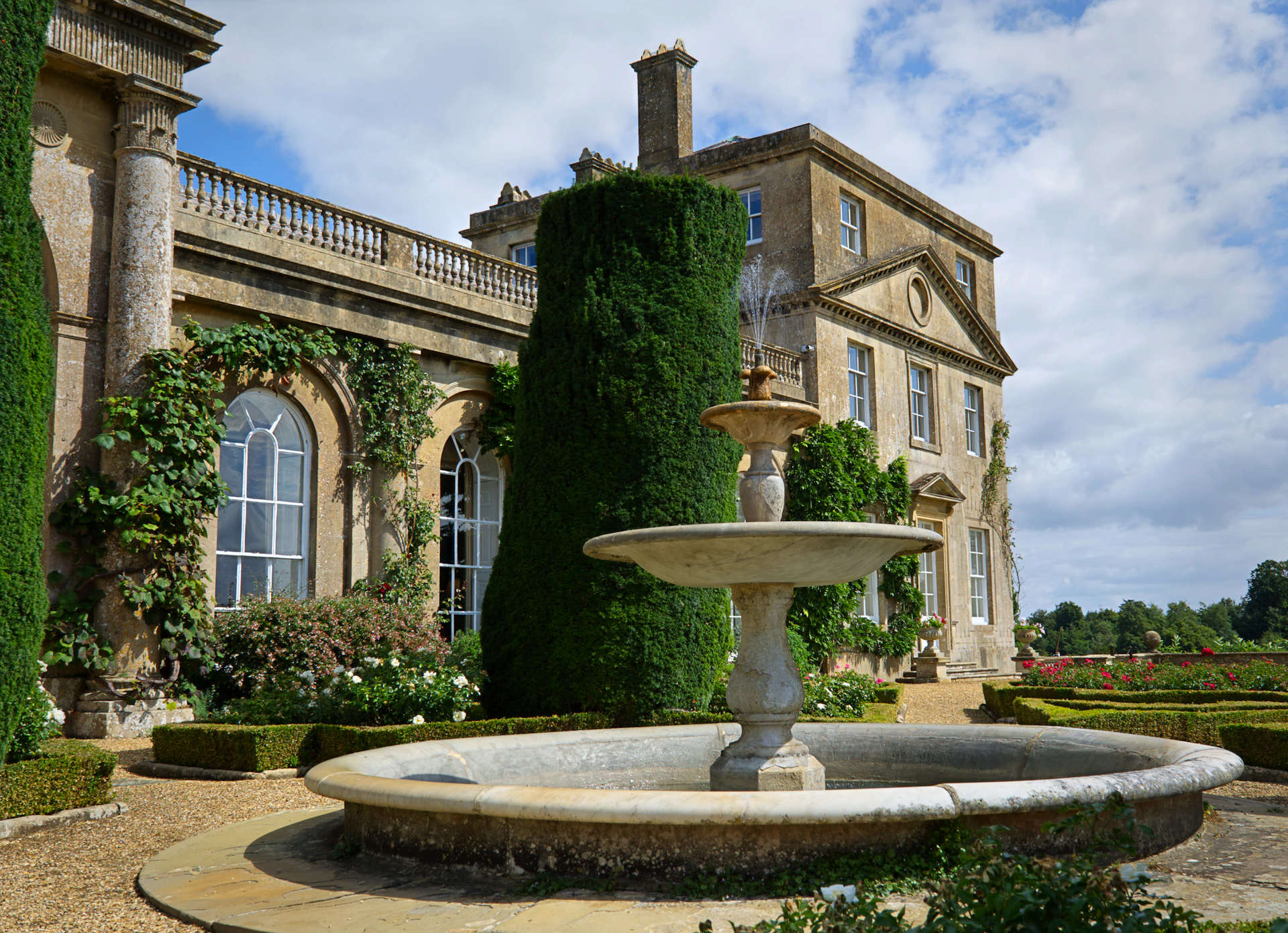Elegant fountain in front of a grand manor house