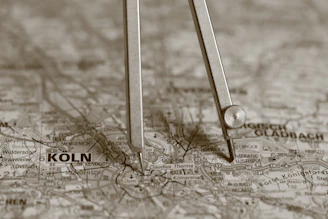 A compass resting on a map with "koln" visible.