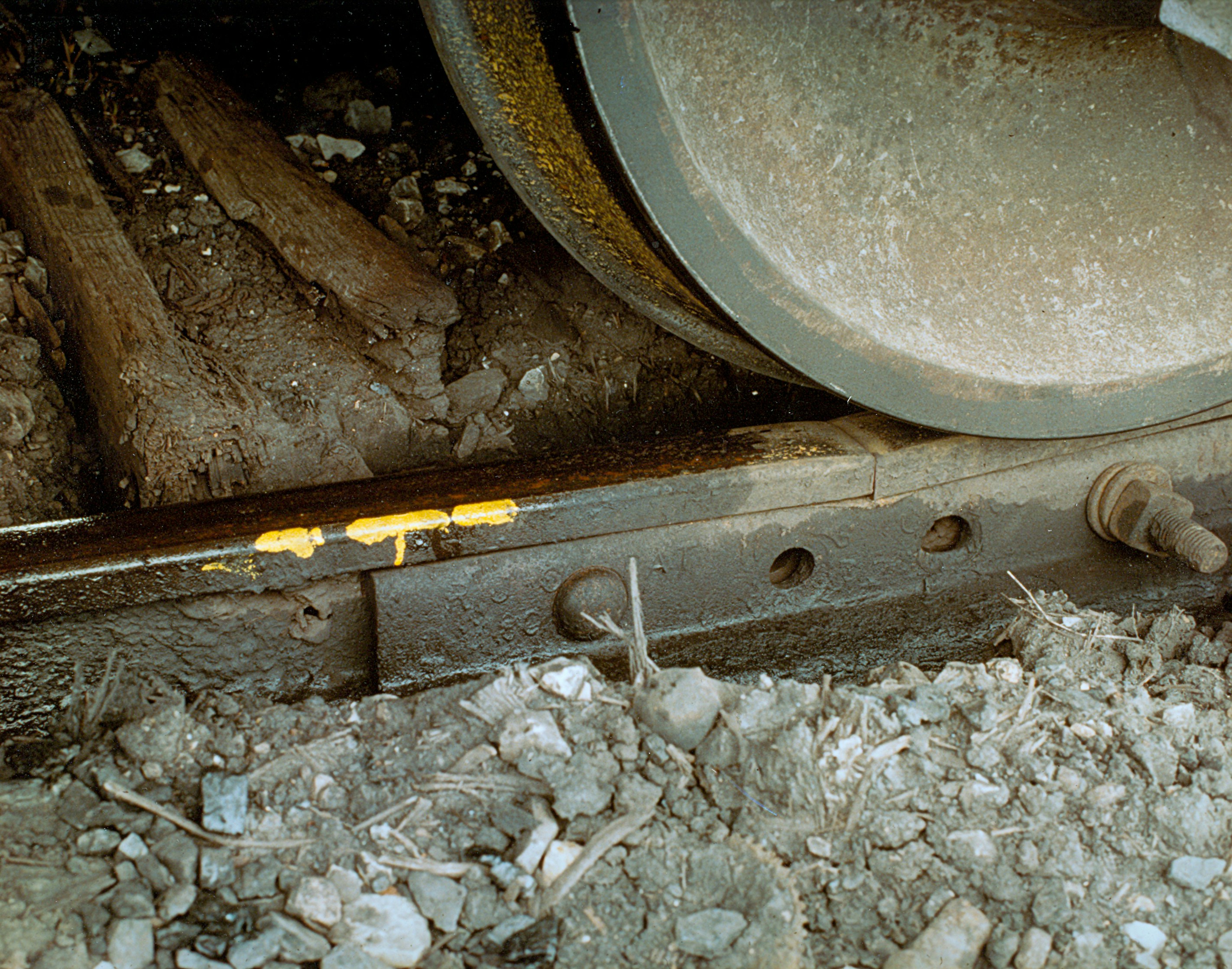 Close-up of a train wheel on tracks with yellow grease on tracks