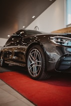 Black luxury car parked on a red carpet