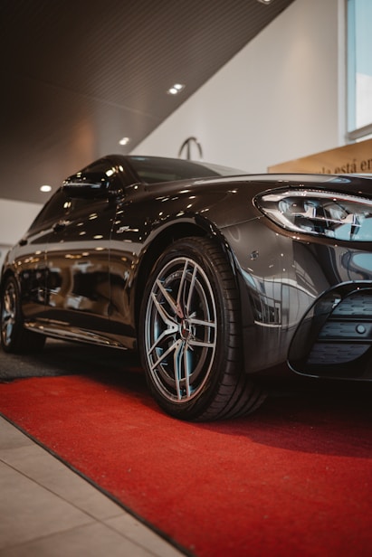 Black luxury car parked on a red carpet