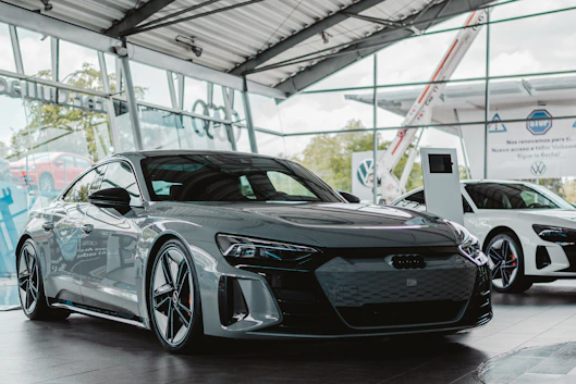 Grey electric car parked inside a modern showroom.