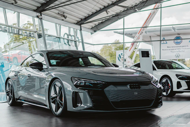 Grey electric car parked inside a modern showroom.