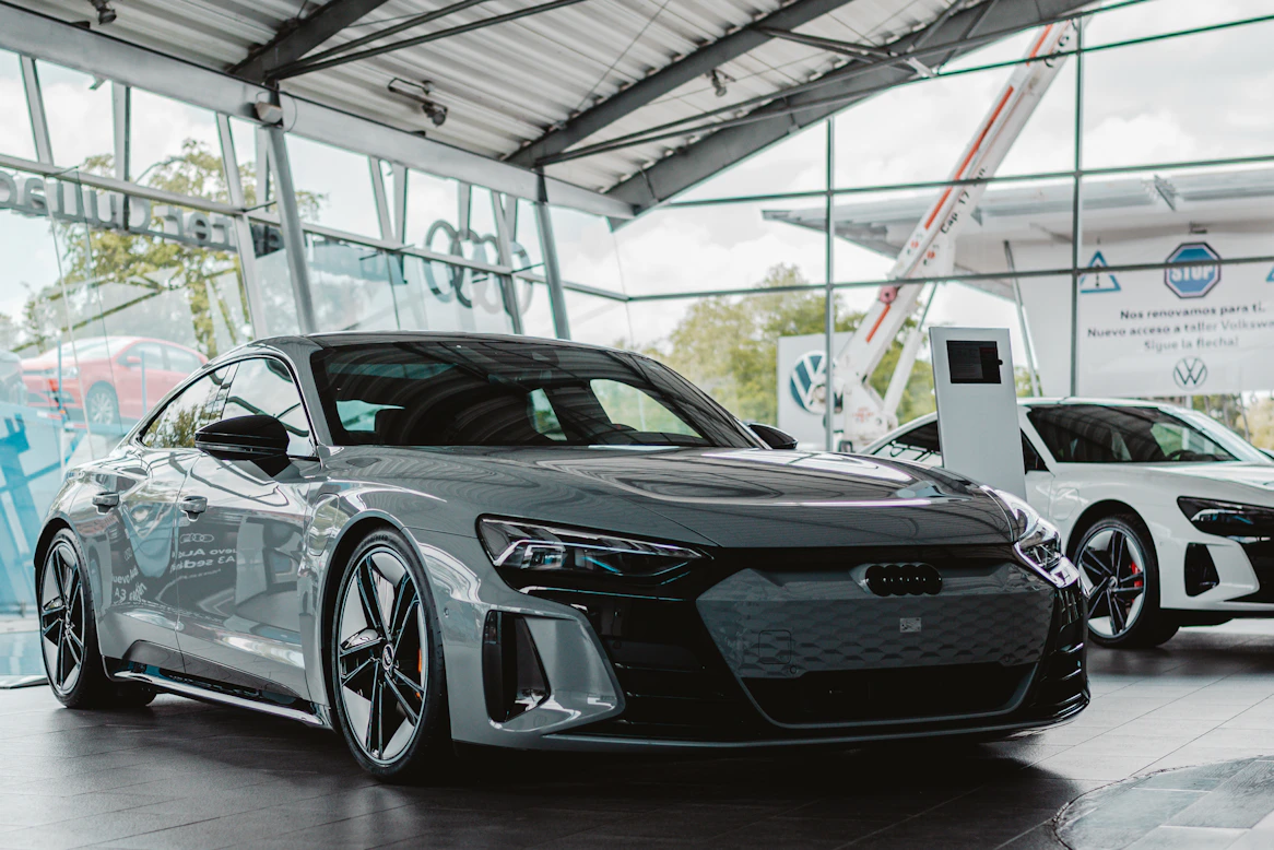 Grey electric car parked inside a modern showroom.