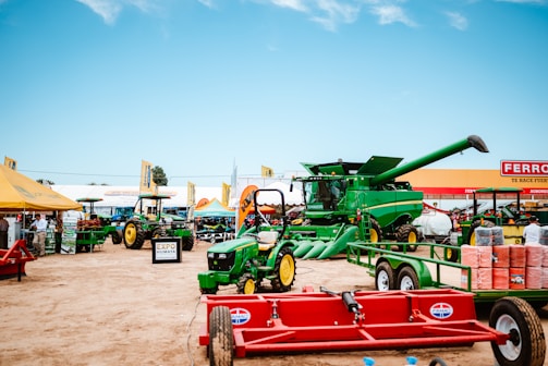 Green tractors and combine harvester at outdoor exhibition