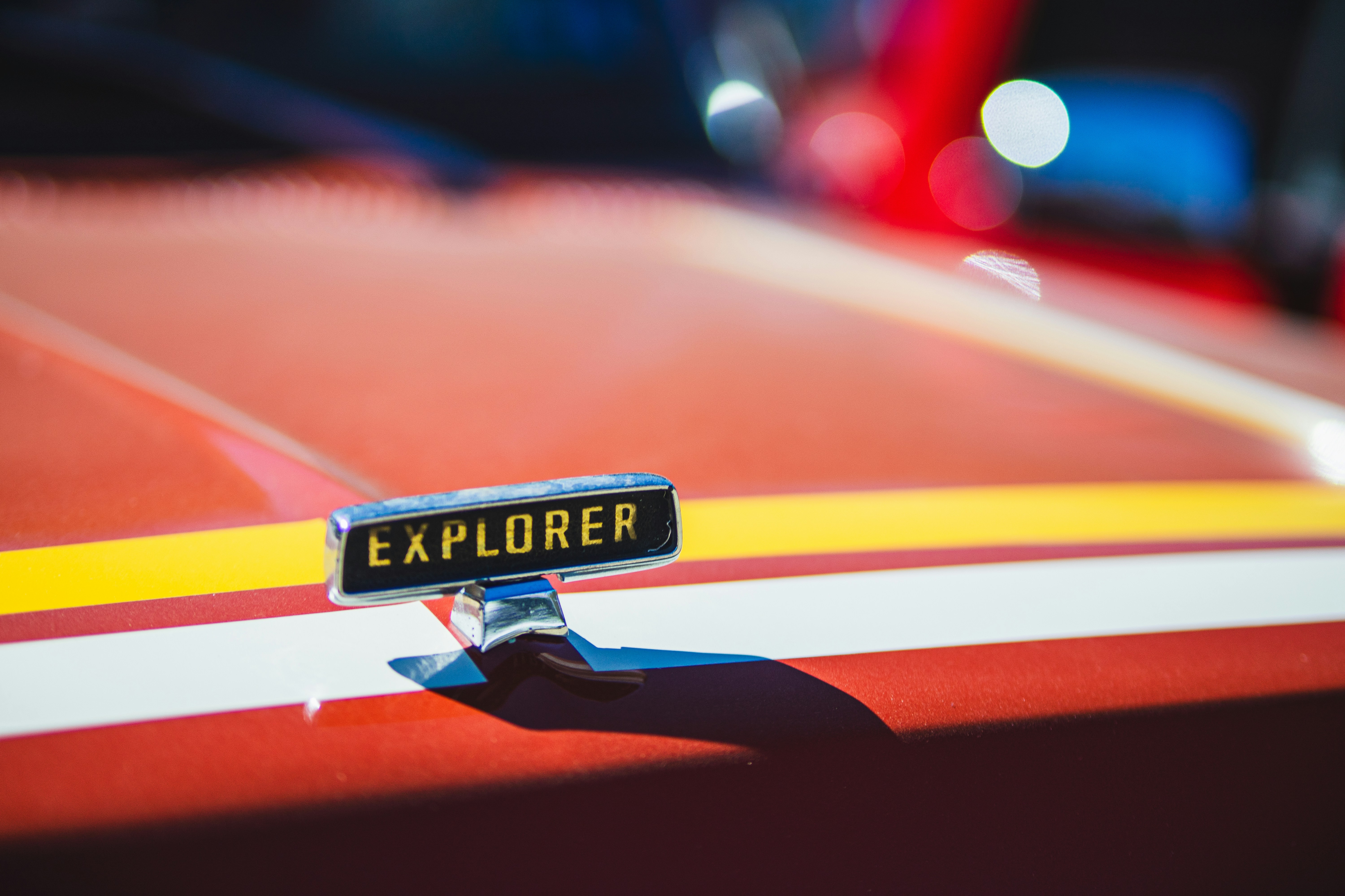 Chrome emblem on a red car hood