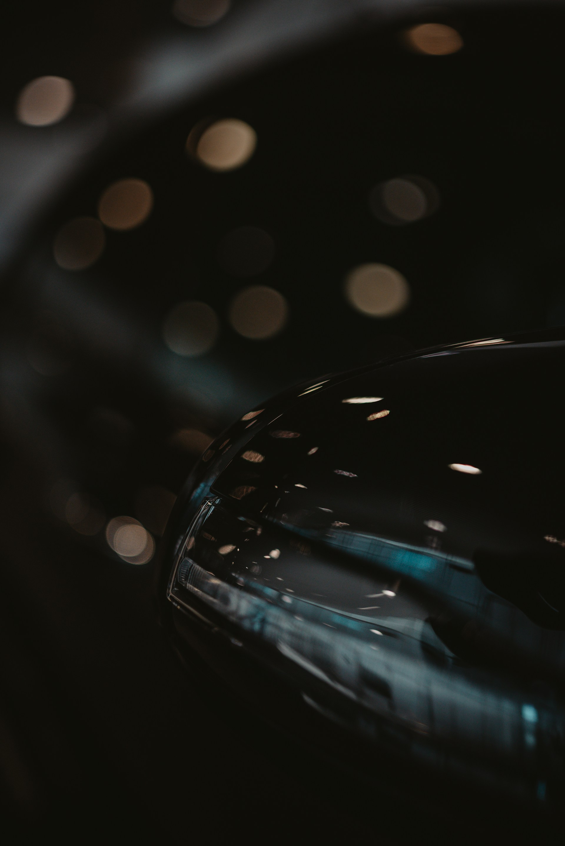 Close-up of a shiny black surface reflecting lights