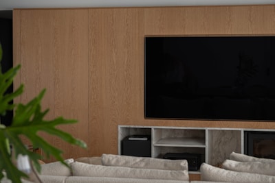 Modern living room with wood paneling and large television.