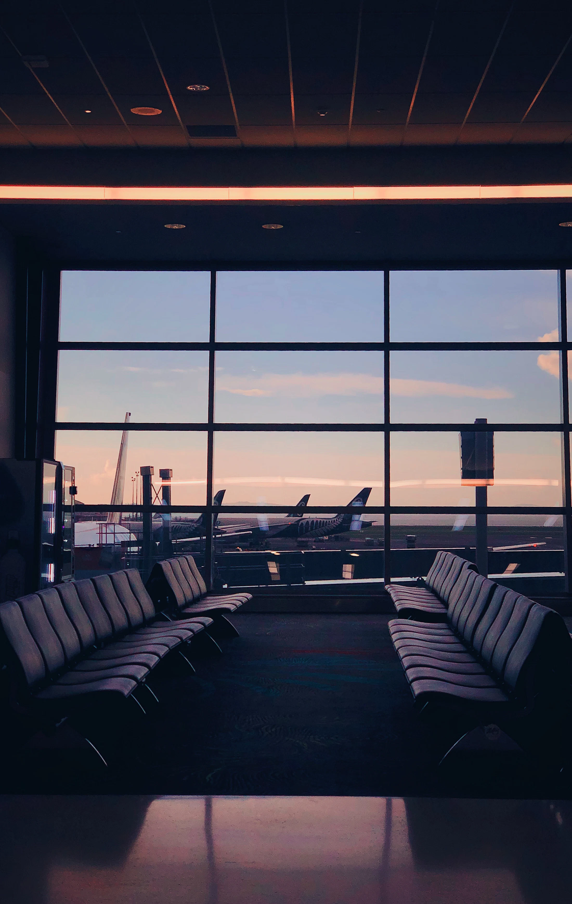 Gün batımında havalimanı bekleme salonunda deri koltuklar (Fotoğraf: Andrei Castanha / Unsplash)