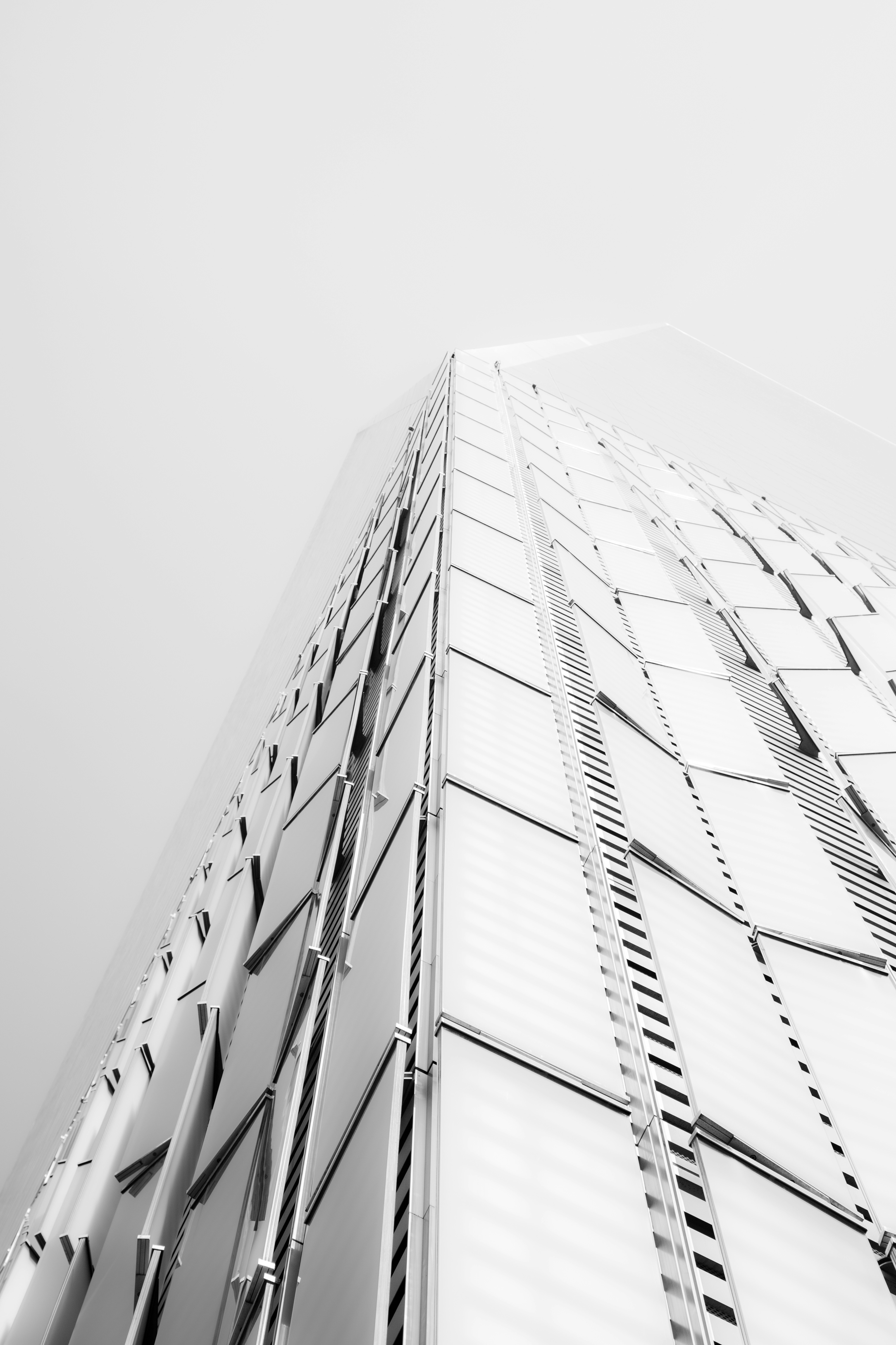 Modern glass skyscraper against a foggy sky